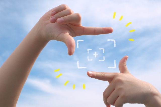 手でカメラのカポーズをとる