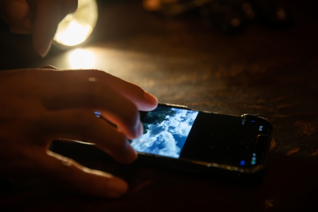 暗い部屋でスマホを触っている